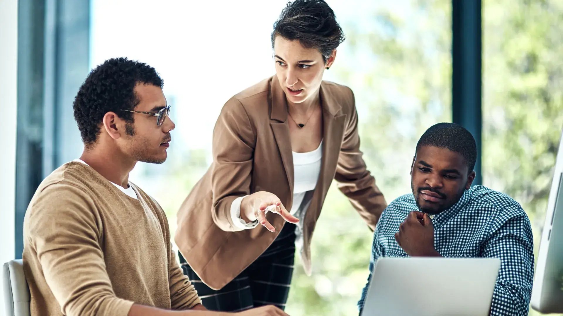 A woman discussing data handling and protection with two of her male colleagues