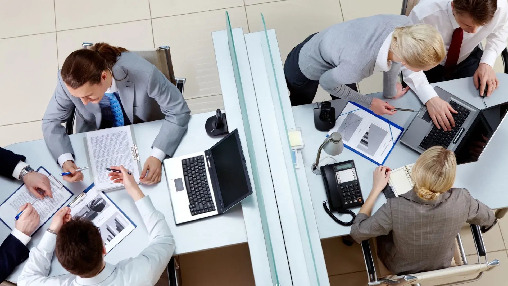 A bird’s eye shot of two office cubicles filled with various employees working