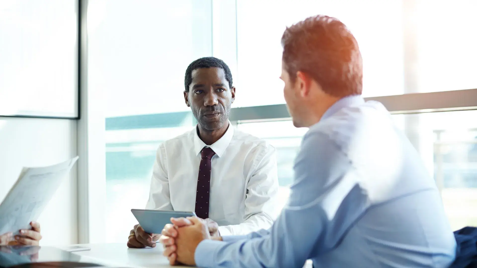 Two male colleagues discussing data breaches in their office conference room